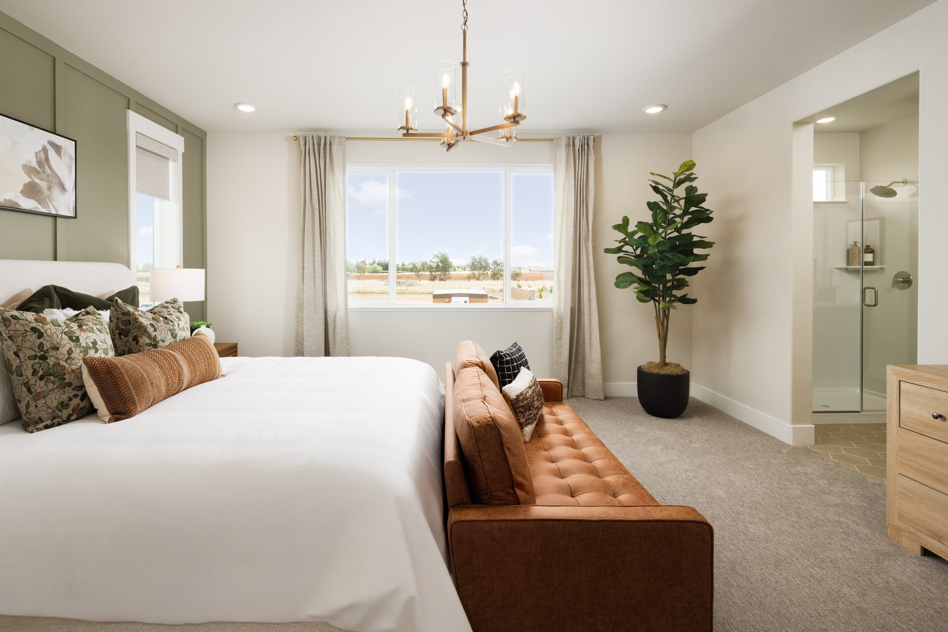 bedroom with gray carpet, green wall, brown sofa at end of bed, and gold hanging light fixture