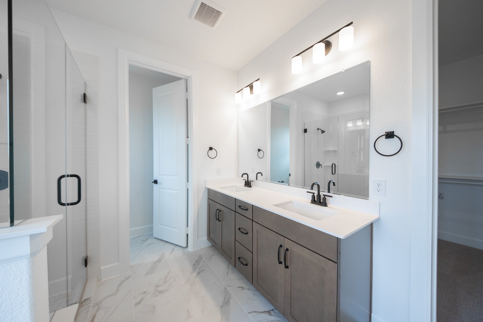 primary bathroom with shower and double vanity