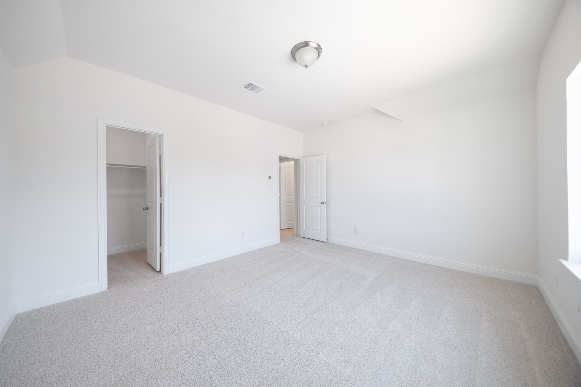 guest bedroom with carpet and walk-in closet