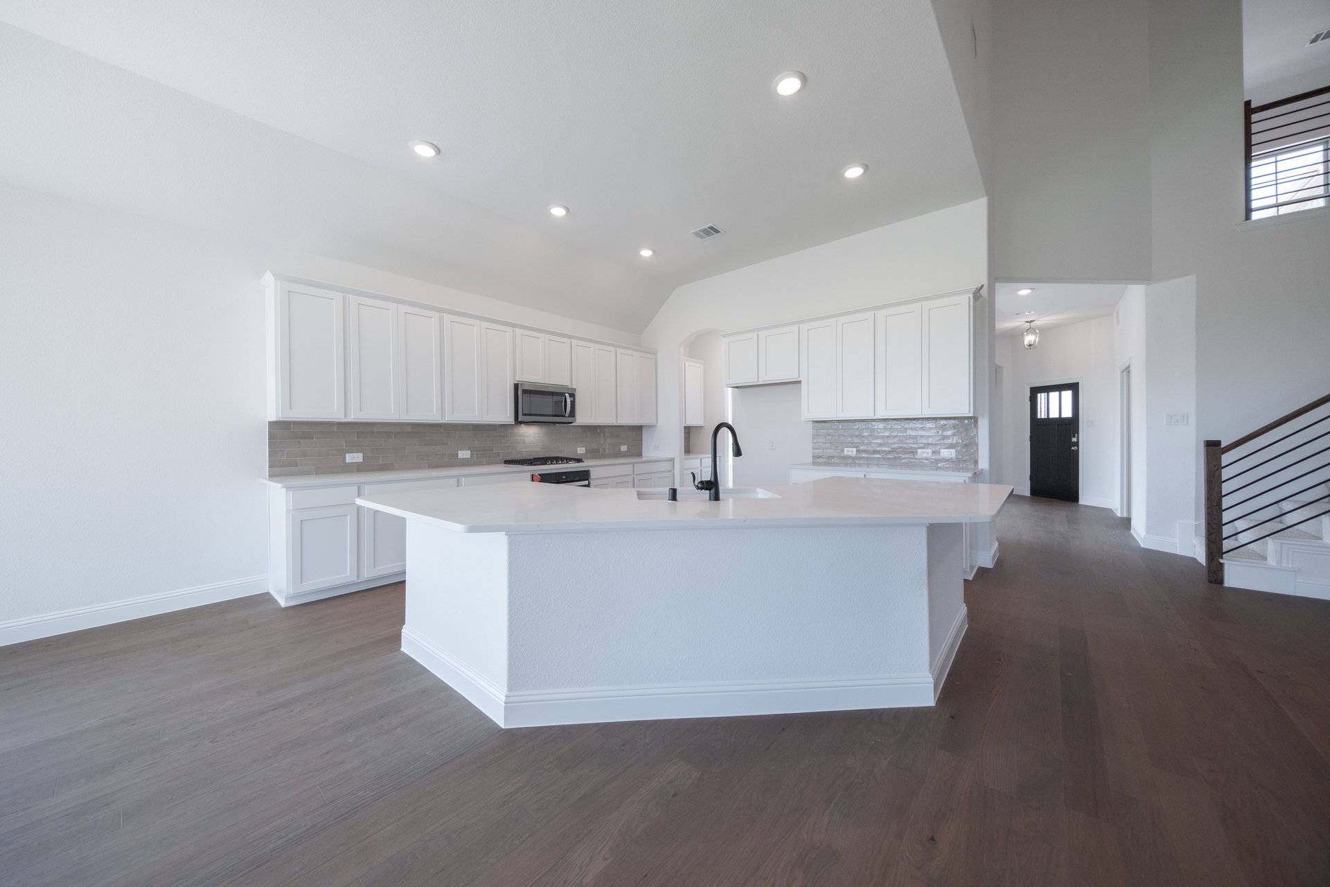 open kitchen with white cabinets and hardwood flooring