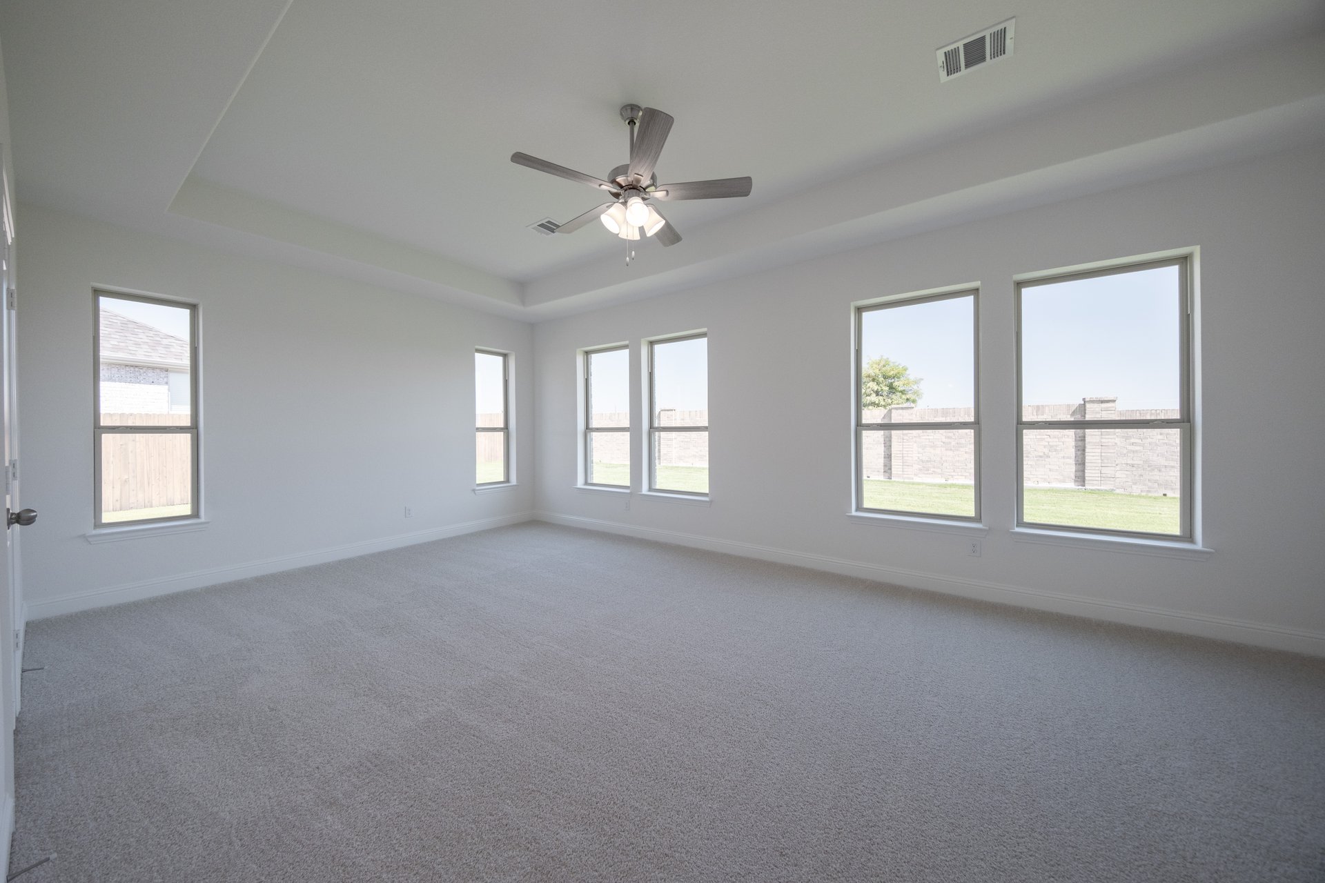 spacious primary bedroom with carpet and windows