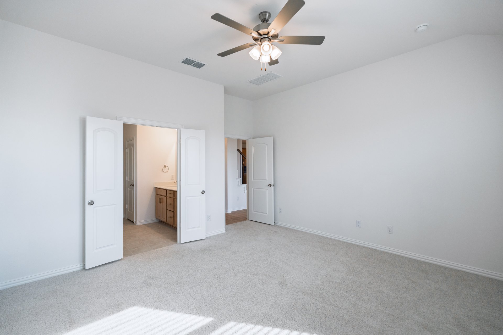 primary bedroom with carpet and ceiling fan