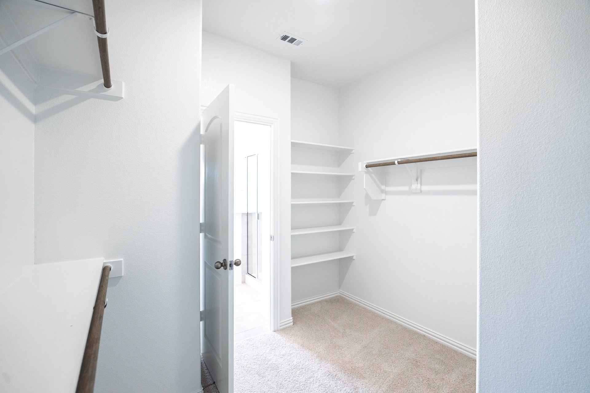 primary closet with carpet and white shelves