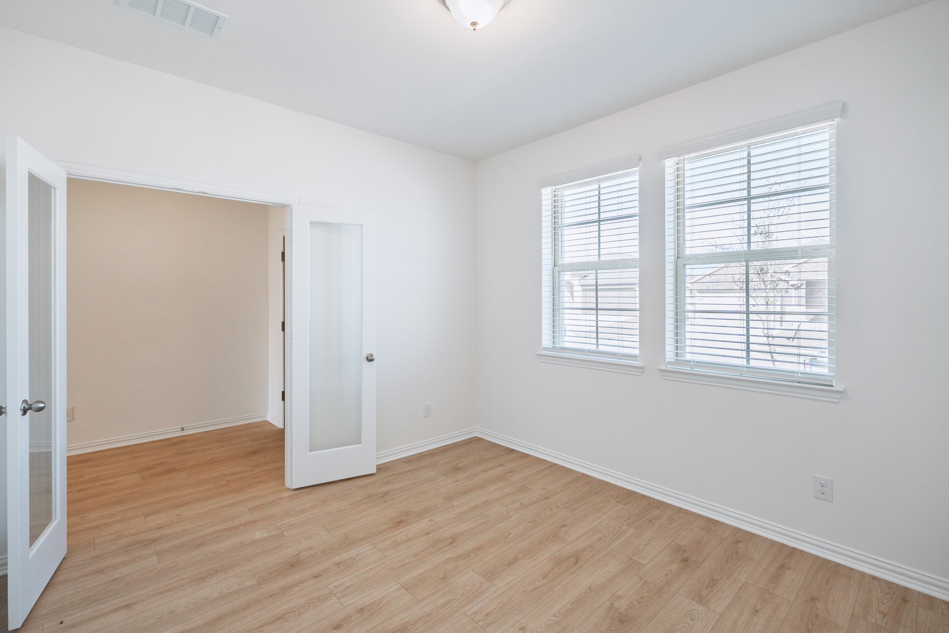 study with french doors and hard wood flooring