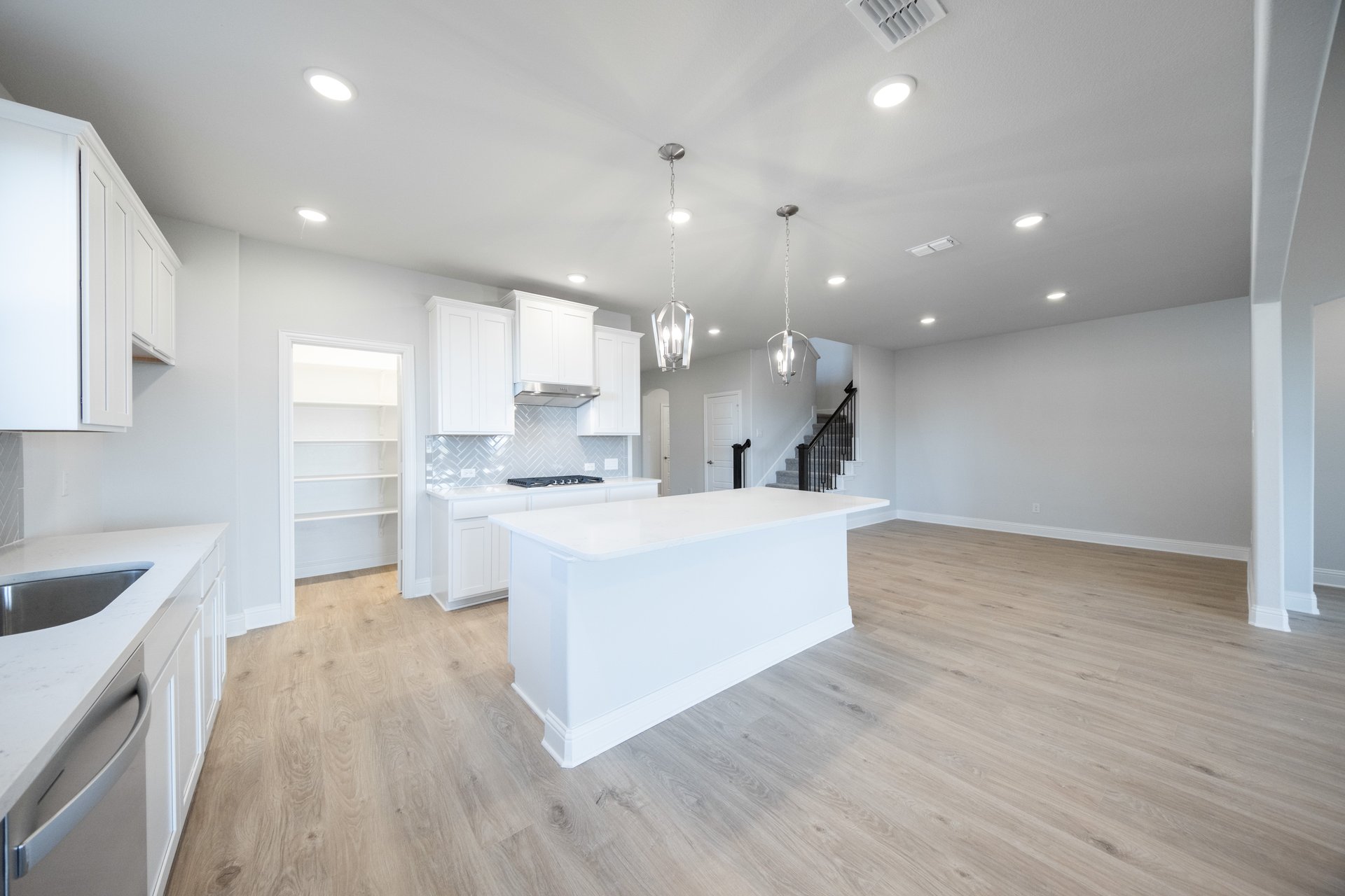 open kitchen with wood floors and white cabinets