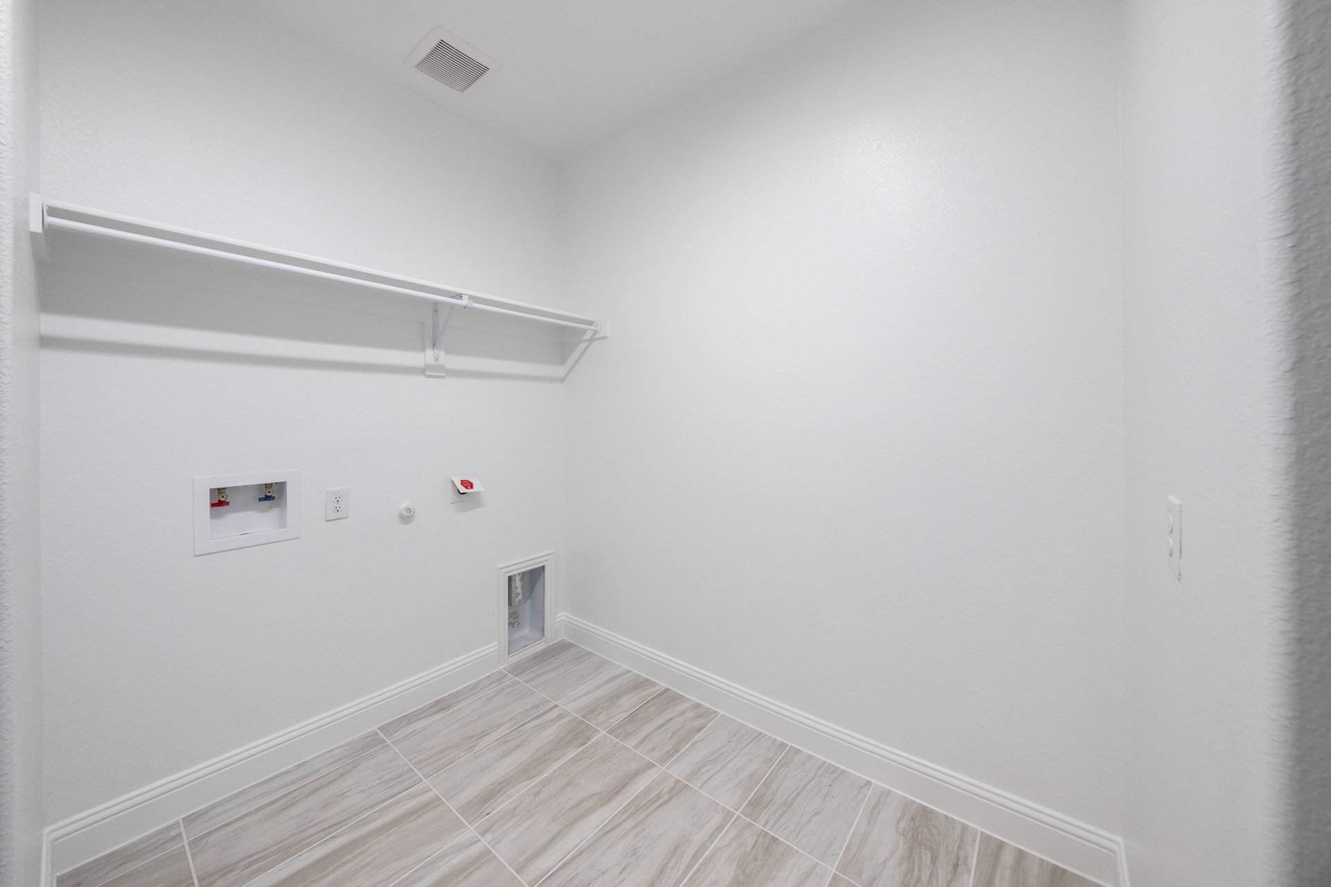 laundry room with tile floors and white shelf