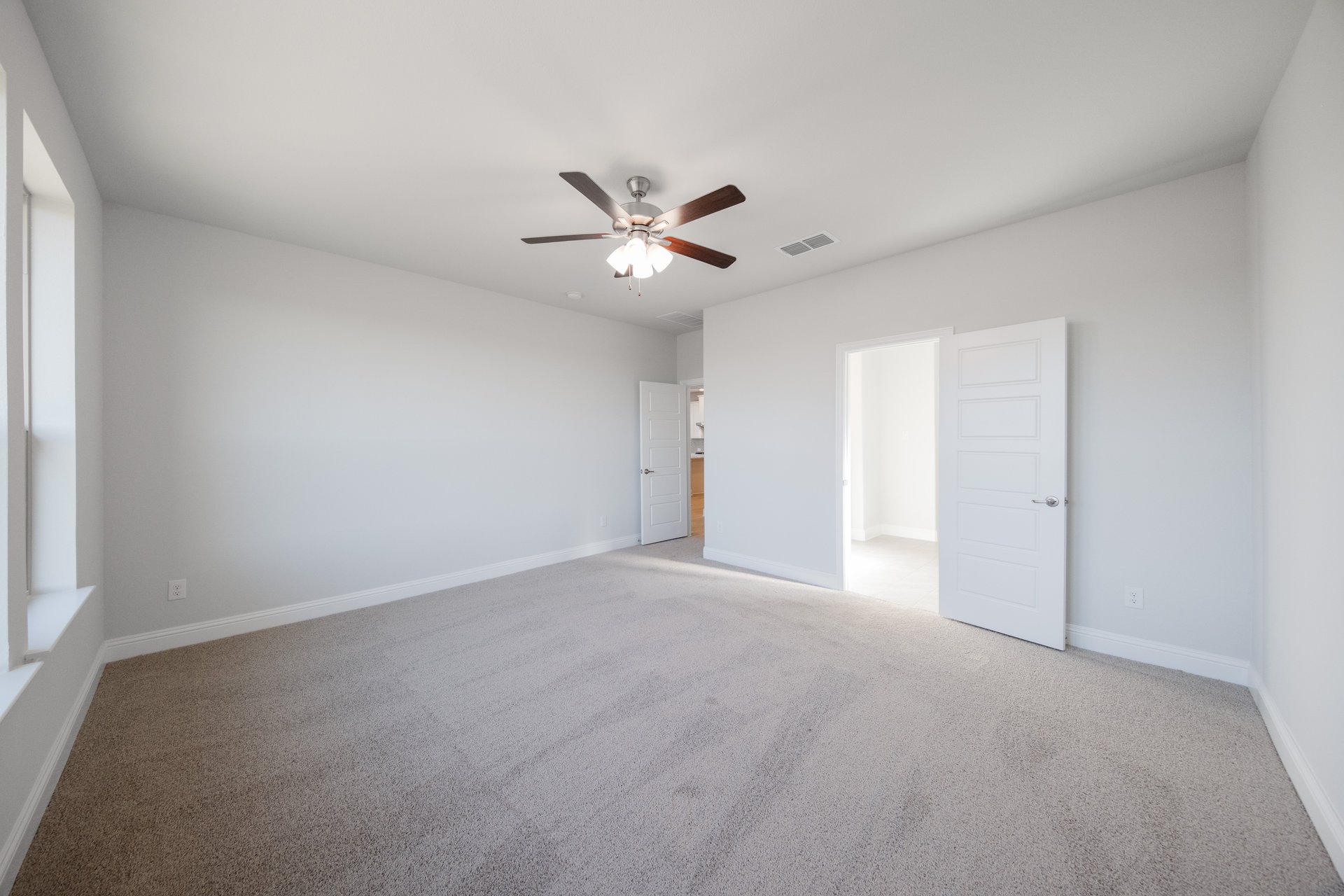 primary bedroom with carpet and windows