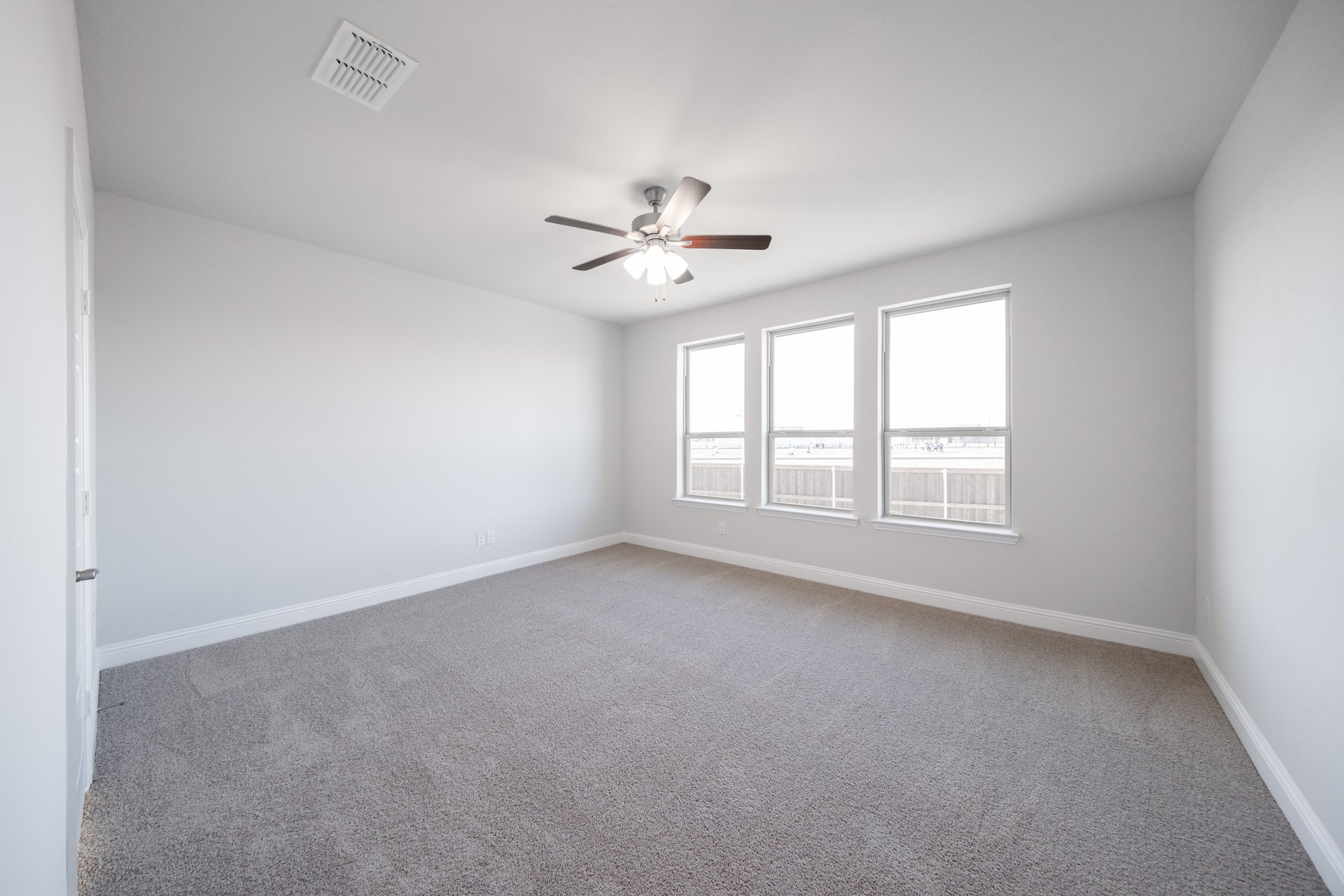 primary bedroom with carpet and windows