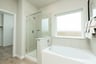 bathroom with white tub and walk-in shower