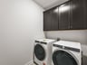 laundry room with brown cabinets and gray flooring