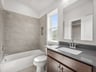 secondary bathroom with sink, soaking tub and window