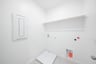 laundry room with tile floors and white shelf