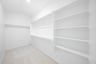 primary bedroom closet with carpet and white shelves