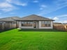 backyard with landscaped grass and brown fence