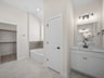 primary bath with white flooring, a sink and a soaking tub