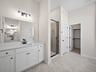 primary bathroom with white flooring, sink and walk-in shower