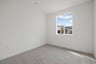 bedroom with tan carpet, white walls, and window
