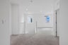 loft with tan carpet, white walls, recessed ceiling lights, and two windows