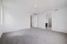 bedroom with tan carpet, white walls, and view of attached bathroom