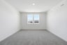 loft with tan carpet, white walls, and two windows