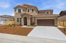 front exterior of brown two-story spanish style home