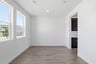dining room with wood floors, white walls, recessed ceiling lights, and two windows looking out to the front yard