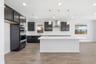 kitchen with wood floors, espresso cabinets, white quartz counters, island, and window above sink