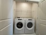 laundry with a washer, dryer and a wire shelf