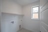 laundry room with tile floors and white shelf