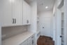 mudroom with wood floors and white shelves with bench