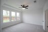 primary bedroom with carpet and ceiling fan
