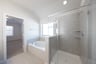 bathroom with large soaking tub and walk-in shower