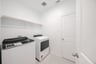 laundry room with tile floors, washer, and dryer