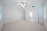 primary bedroom with carpet and ceiling fan