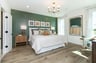 bedroom with wood plank flooring and green accent wall