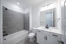 bathroom with tub and white cabinets 