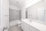 bathroom with white countertops and tile 