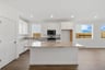 kitchen with white cabinets, island, wood floors, and multiple windows