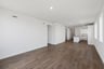 great room with wood floors, white walls, recessed ceiling lights, and view of kitchen