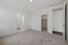 bedroom with tan carpet, walk-in closet, and view of attached bathroom