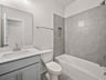 bathroom with soaking tub, quartz countertops & a sink