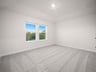 bedroom with carpet, windows & a sloped ceiling