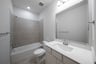 bathroom with white countertops and tile 