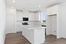 kitchen with white cabinets & counters, island, wood floors, and window