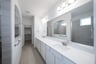 bathroom with large mirror and white countertops 