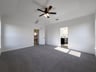 primary bedroom with carpet and ceiling fan