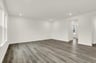 great room with wood plank flooring and white walls