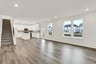 great room and open-concept dining area with wood plank flooring and white walls