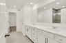 bathroom with white cabinets and dual sink vanity