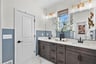 primary bathroom with two sinks and vanity lighting